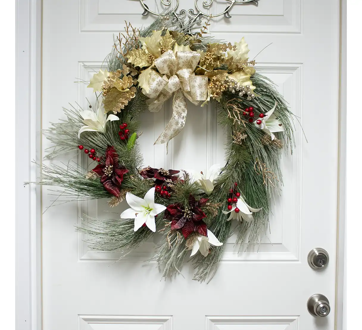 Perfect for doors, mantels, or walls, this wreath brings a timeless elegance to your winter decor. Its combination of frosted pine, radiant lilies, vibrant berries, and golden accents makes it a versatile piece that celebrates the season with style, welcoming guests with warmth and refined beauty.