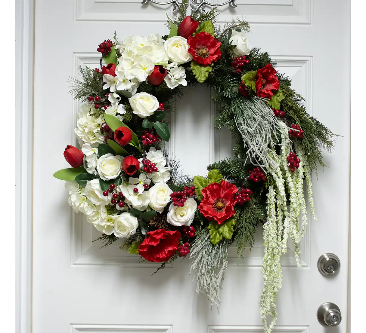 Celebrate the enchantment of the season with a wintery red and white silk door wreath that radiates elegance and festive cheer. Built on a lush evergreen and pine base, this wreath captures the timeless beauty of winter foliage, serving as a vibrant foundation for its stunning floral accents. The rich greenery is accented by clusters of lifelike pine needles and sprigs, bringing texture and fullness to the design. Nestled among the foliage are radiant silk blooms in deep, velvety red and crisp, pure white. Roses, amaryllis, or poinsettias may take center stage, their lush petals adding sophistication and seasonal charm. Smaller, complementary flowers and delicate buds are interspersed throughout, enhancing the arrangement with subtle layers and depth. Touches of frosted accents, such as snowy twigs or glittering foliage, evoke the serene magic of freshly fallen snow. Sprigs of red berries add a cheerful pop of color, while muted green or silver foliage balances the palette and softens the look.